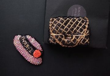 Set of brooches pink hat with a flower and a black handbag on a chain.