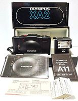 Olympus XA2 35mm Film Flash Camera w/Olympus D-Zuiko 1:3.5 f=35mm Lens Made In Japan with FLASH ASA 25, 50, 100, 200, 400, 800 with Olympus Electronic Flash A11 Atachment (Black in Color)