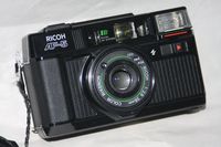Ricoh Company Lty. Ricoh AF-5 35mm Film Camera Ricoh AF System w/ Ricoh 1:2.8 38mm Color Rikenon Lens w/ ISO 25, 64, 100, 200, 400, 1000 ASA 35mm Film Camera (Black Color)